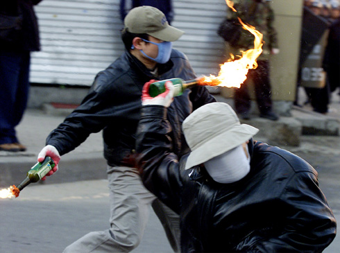 SOUTH KOREAN PROTESTERS THROW FIRE BOMBS AT RIOT POLICE IN PUPYONG.